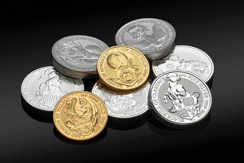 Shiny gold and silver bars and coins arranged on a dark surface representing precious metal investment