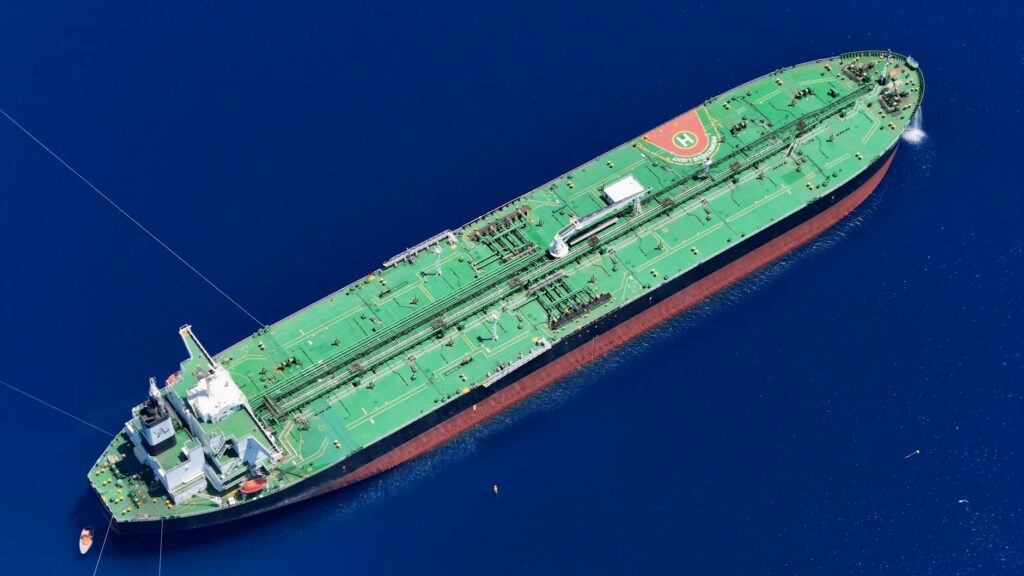 Large oil tanker ship sailing on open sea with cargo barrels representing global oil trade and blockade